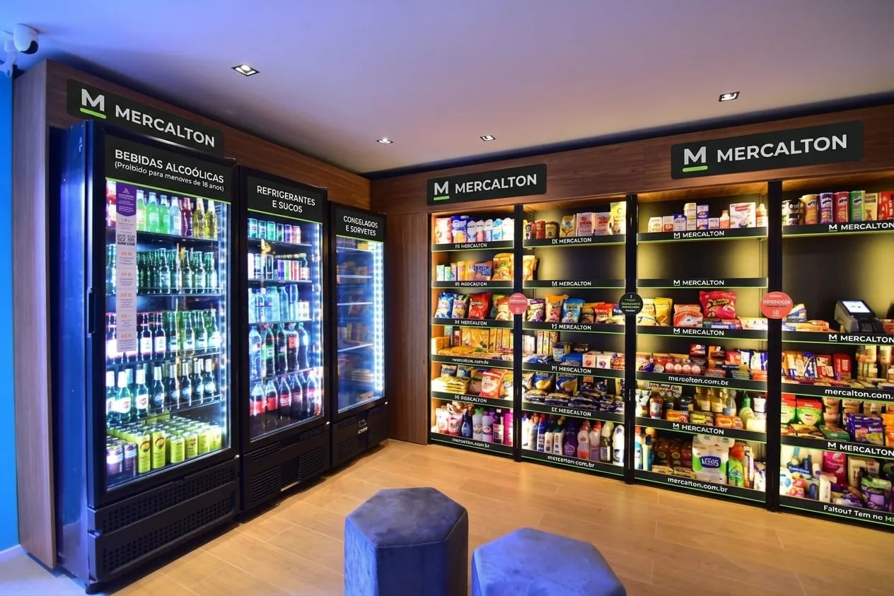 Mercadinho MERCALTON com geladeiras de bebidas, refrigerantes e congelados e prateleiras de produtos com a marca