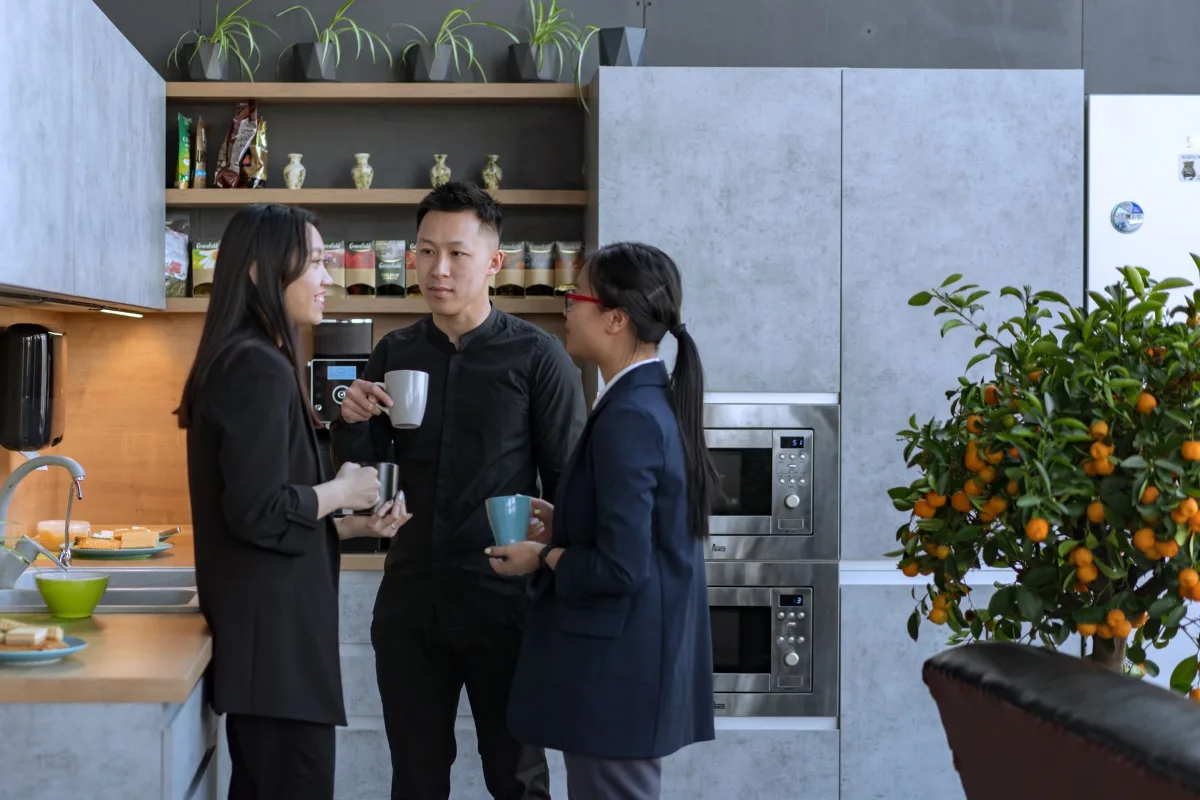 Colegas de trabalho conversando com café na copa de um escritório