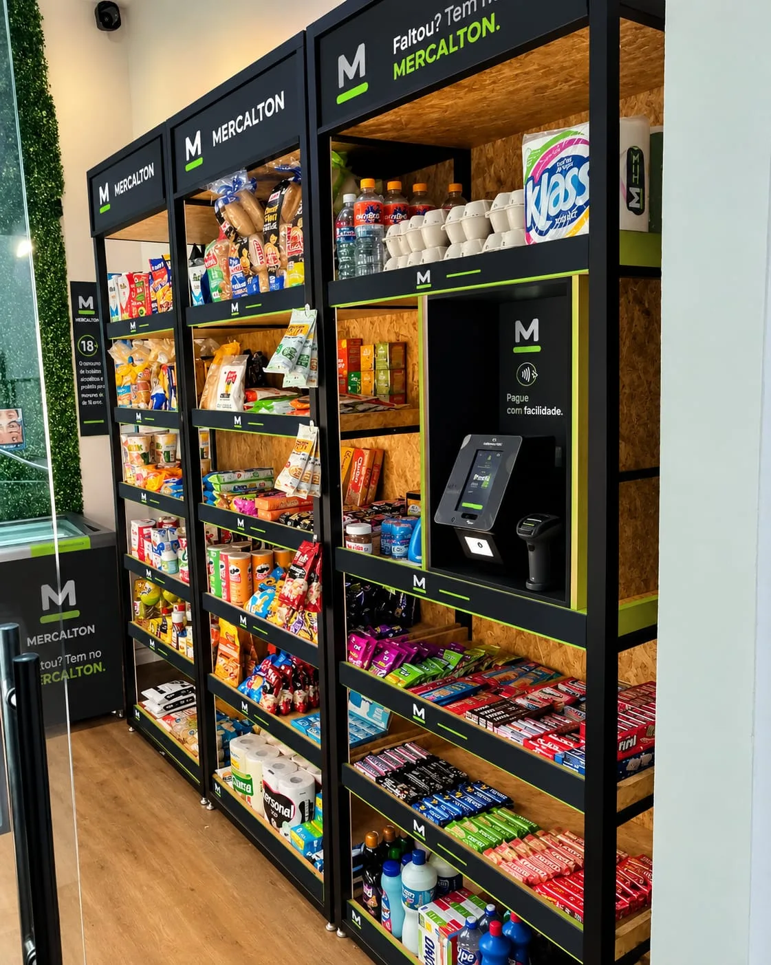 Prateleiras de um mercadinho MERCALTON com produtos do dia a dia, terminal de pagamento e leitor de código de barras